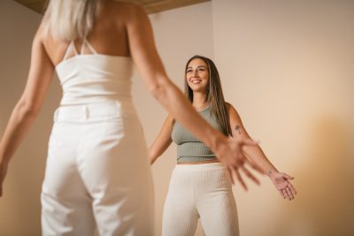 Zwei Frauen praktizieren l&auml;chelnd Energiearbeit in entspannter Atmosph&auml;re, um innere Balance und Harmonie zu f&ouml;rdern.