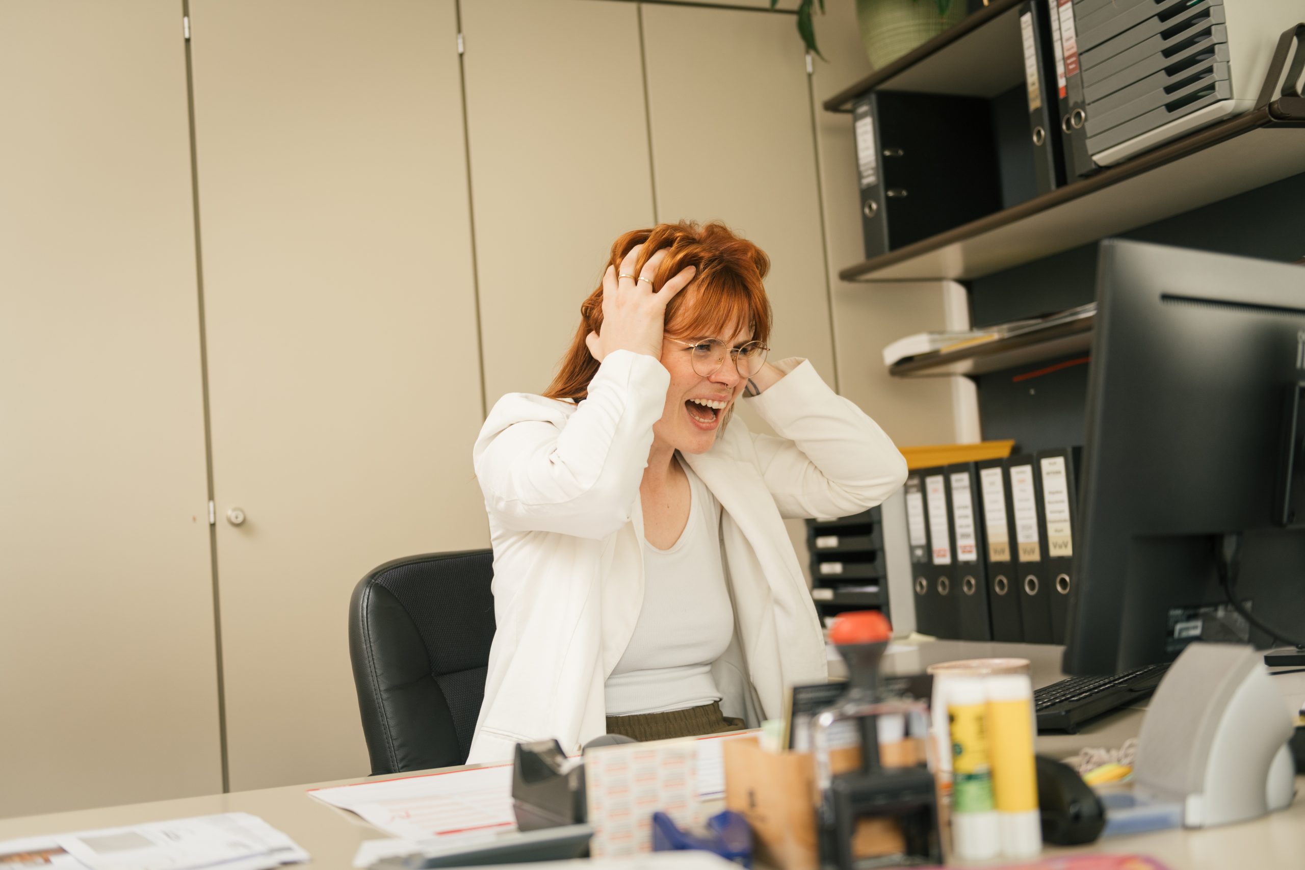 Gestresste Frau am Schreibtisch, die Energiearbeit in stressigen Situationen benötigt.