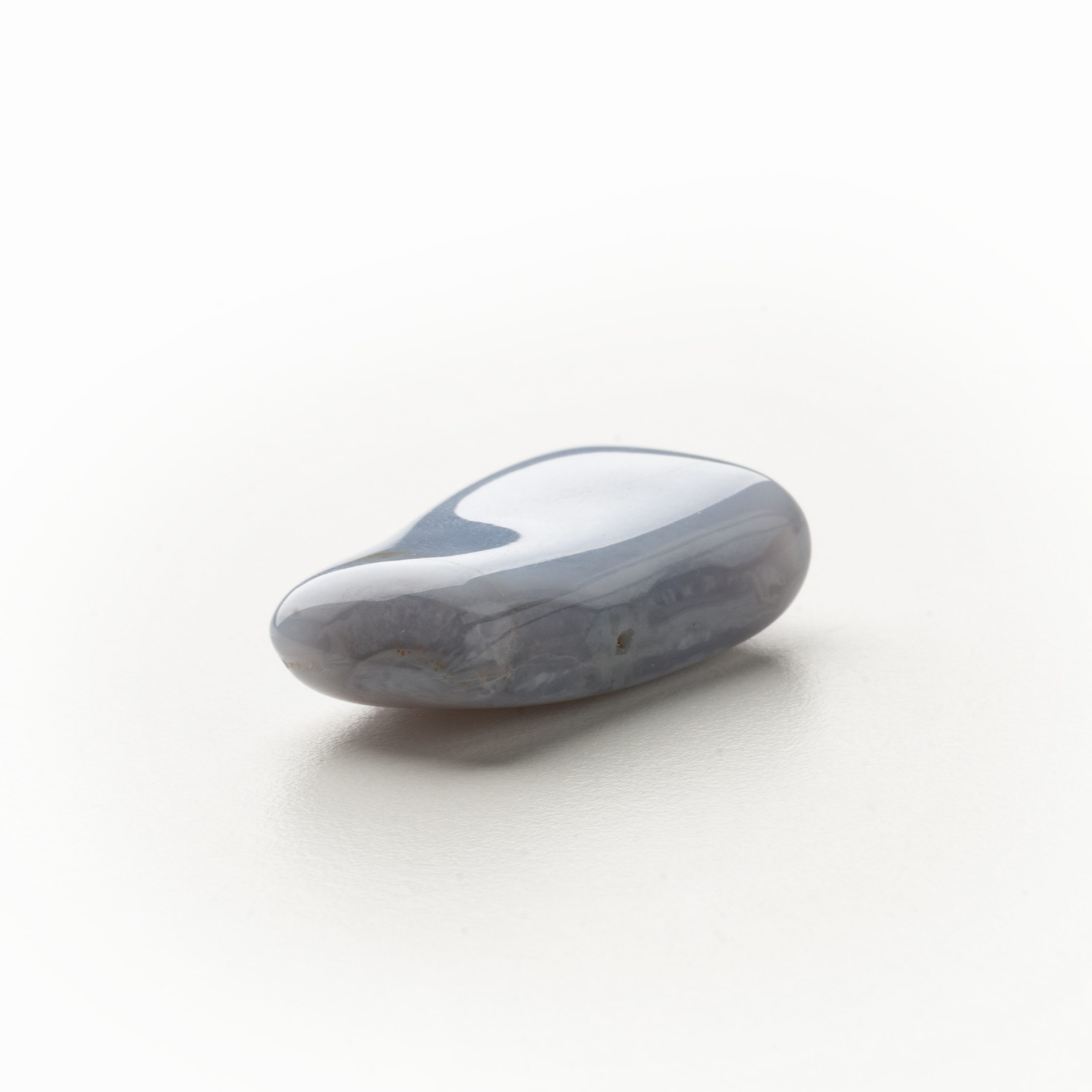 Shop-4663 Blauer Chalcedonstein für Energiearbeit, auf hellem Hintergrund liegend, fördert Harmonie und innere Ruhe.