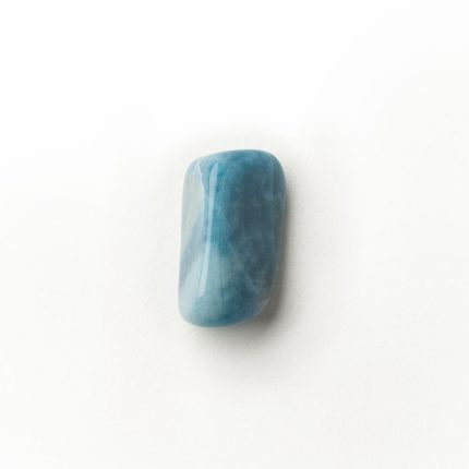 Glatter blauer Edelstein für Energiearbeit auf weißem Hintergrund, ideal zur Förderung von Balance und Harmonie.
