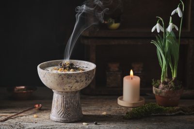 R&auml;uchergef&auml;&szlig; mit Rauch, Kerze und Schneegl&ouml;ckchen f&uuml;r beruhigende Energiearbeit und spirituelle Atmosph&auml;re.