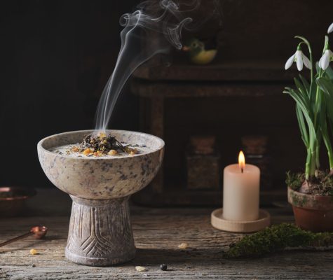 Räuchergefäß mit Rauch, Kerze und Schneeglöckchen für beruhigende Energiearbeit und spirituelle Atmosphäre.