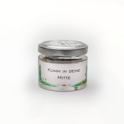 Kleines Glas für Energiearbeit, beschriftet mit Komm in deine Mitte und verziert mit grünen Elementen.