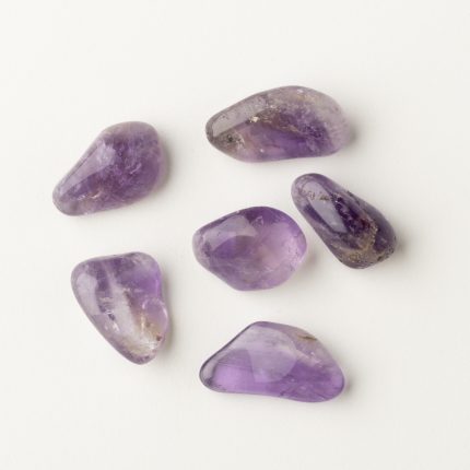 Lila Amethystkristalle für Energiearbeit und spirituelles Wachstum auf weißem Hintergrund.